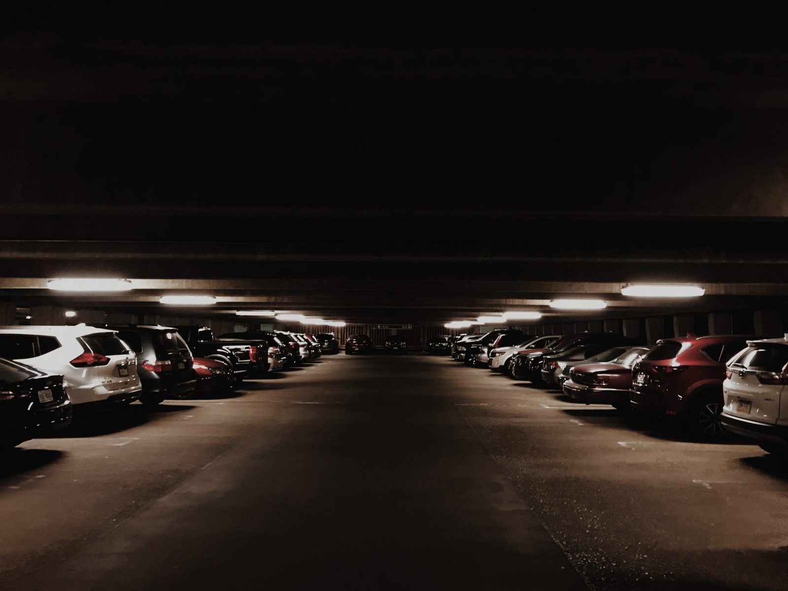 Cars parked in a covered, lit compound